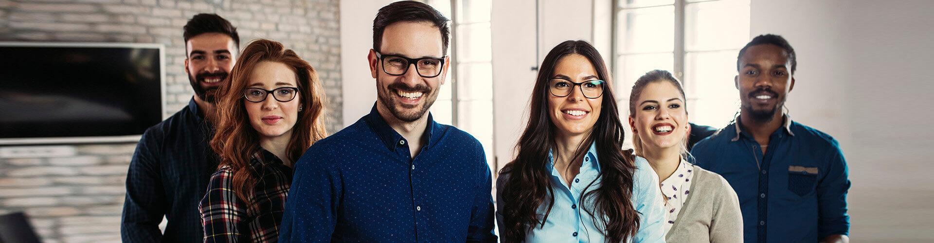 Programa Porque Somos Asi - Grupo de personas en fila sonriendo unas al lado de otras en la oficina